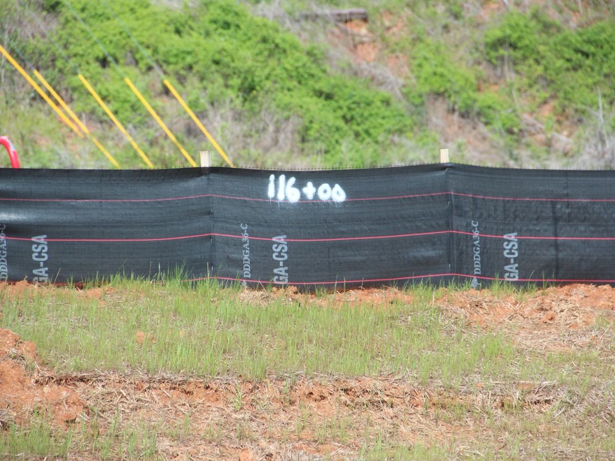 Silt fence installed along the downhill edge of a cleared construction site