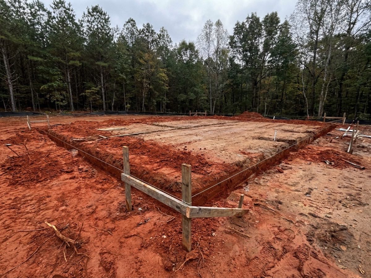Freshly excavated foundation footing trenches on a prepared building pad