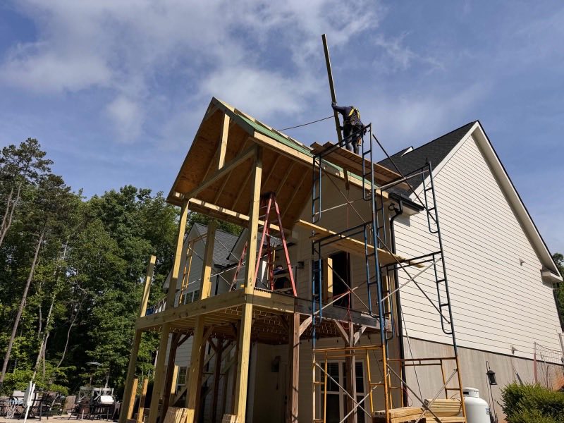 Tall timber-framed addition under construction with scaffolding in place
