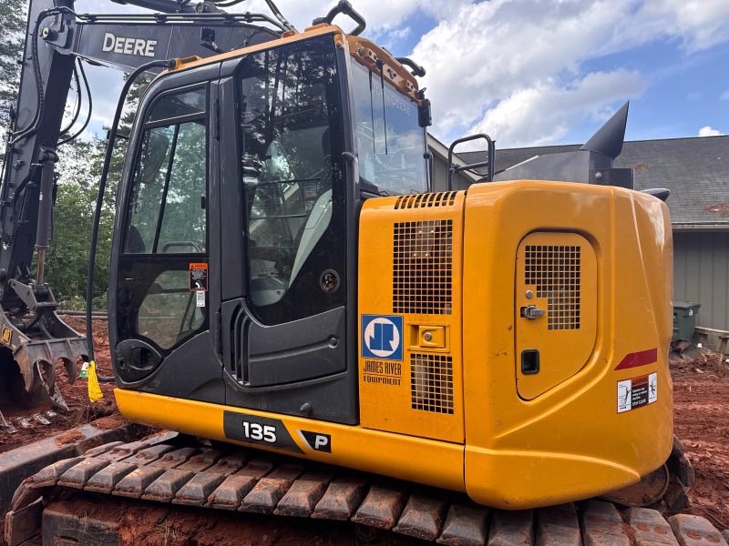 Tracked excavator parked on a jobsite with red clay under the tracks
